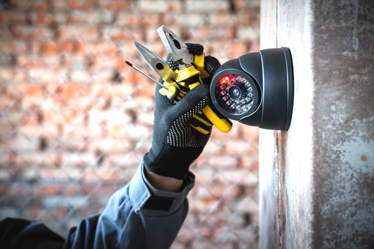 Security camera technician installing a bar security camera